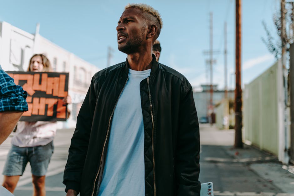 A diverse group of adults protesting for equal rights on an urban street in daylight.