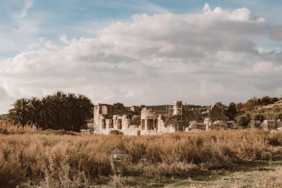 Explore ancient ruins amidst countryside fields and lush vegetation under a cloudy sky.